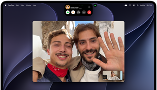 MacBook Pro med PROLED XDR-skjerm i fargen sølv viser en videosamtale med to personer i en solrik by som vinker til en person som er hjemme