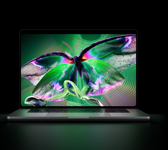 MacBook Pro med PROLED XDR-skjerm, åpent lokk, i fargen sølv, skjermen viser et detaljert bilde med høy kontrast og sterke farger, skjermen lyser opp tastaturet