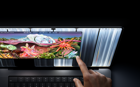 MacBook Pro med PROLED XDR-skjerm i fargen stellarsvart, brukeren justerer størrelsen på et vindu på skjermen med fingeren.