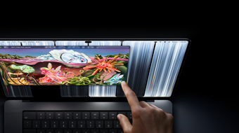 MacBook Pro med PROLED XDR-skjerm i fargen stellarsvart, brukeren justerer størrelsen på et vindu på skjermen med fingeren.