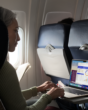 En person bruker en MacBook Air om bord i et fly for å vise Macens lange batteritid