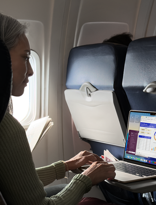 En person bruker en MacBook Air om bord i et fly for å vise Macens lange batteritid