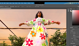 MacBook Air-skjerm med Adobe Photoshop åpent i et vindu med et bilde av en dame i en fargerik, blomstrete kjole, som viser lysstyrken til Liquid Retina-skjermen